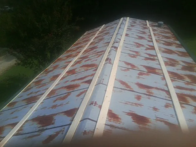 Rusted metal roof panels with new wood purlins before replacement — Storm Damage Roof Repair in Farmland by Roofing Brothers