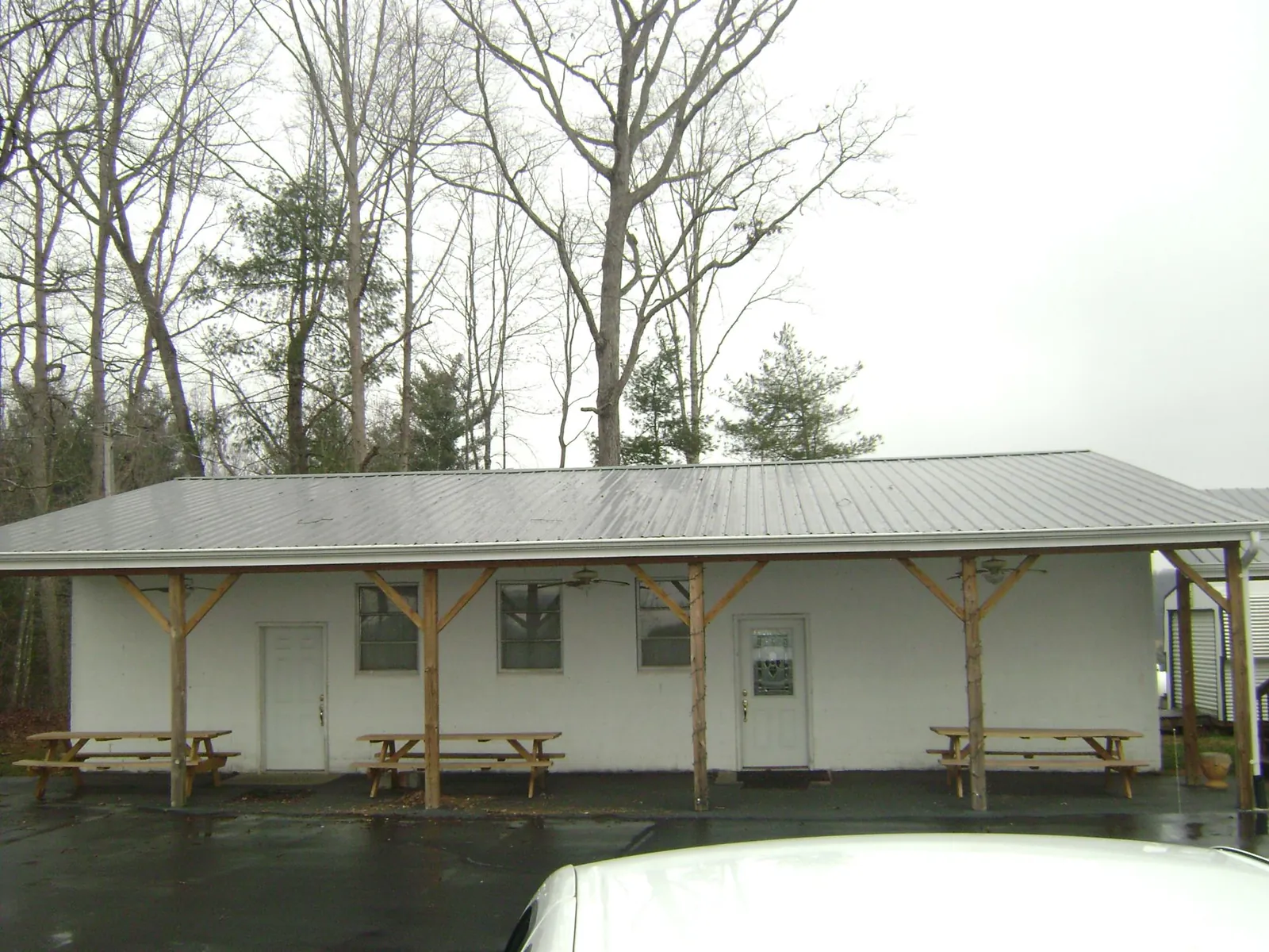 Gray metal roof over a block building with a timber post porch in Farmland