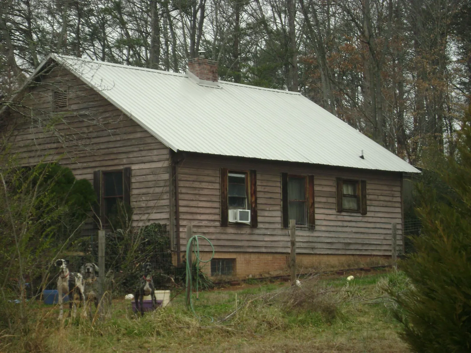 White metal roof on an old wood sided farmhouse, from a Metal Roof Installation job in Farmland